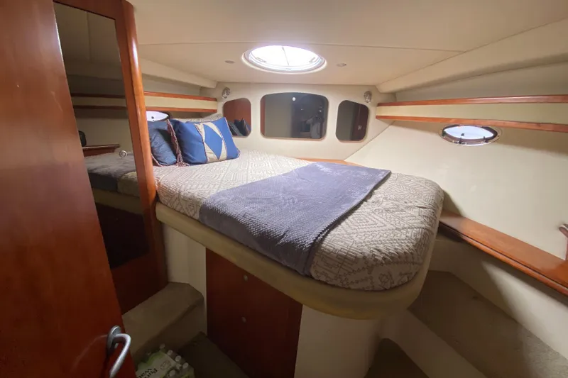 Slide: The Image of 2007 Cruisers Yachts 370 Express cabin interior with bed and porthole. - 45