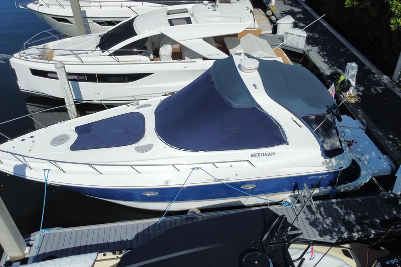 Slide: The Image of 2007 Cruisers Yachts 370 Express docked, featuring a blue and white design. - 5