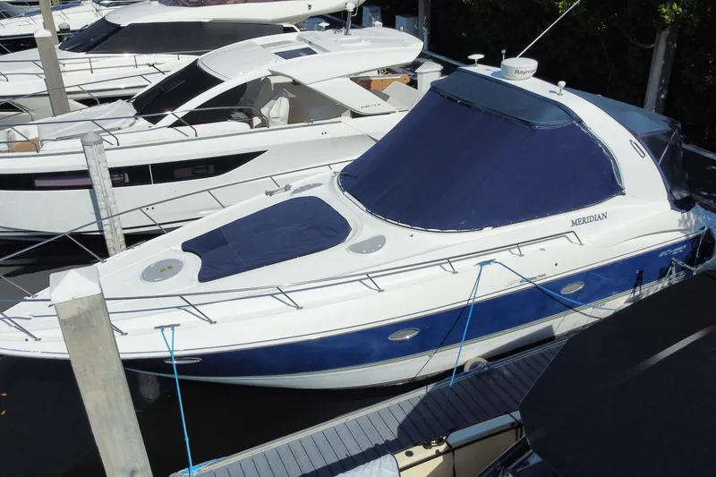 Slide: The Image of 2007 Cruisers Yachts 370 Express docked, featuring sleek design and blue cover. - 7