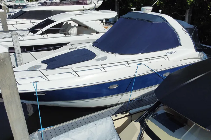 Slide: The Image of 2007 Cruisers Yachts 370 Express docked, featuring blue and white design. - 9