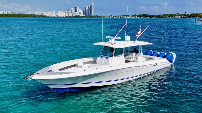 Slide: The Image of 2019 HCB 42 Siesta boat on clear blue water with city skyline in background. - 11