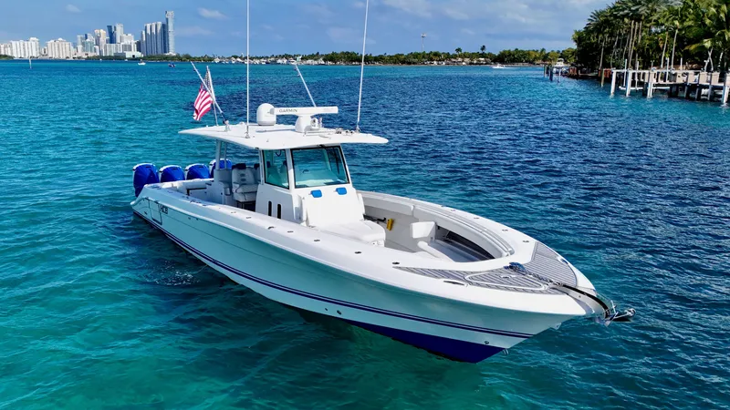 Slide: The Image of 2019 HCB 42 Siesta boat on clear blue water with city skyline in background. - 12