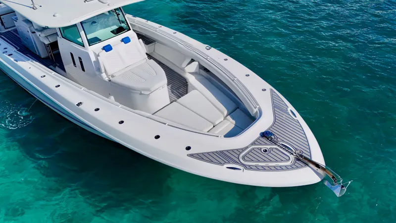 Slide: The Image of 2019 HCB 42 Siesta boat on clear turquoise water, showcasing sleek design and spacious deck. - 16