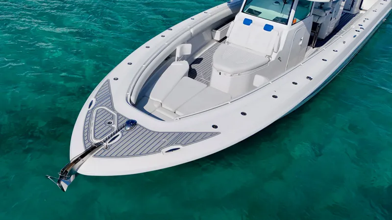 Slide: The Image of 2019 HCB 42 Siesta boat on clear turquoise water, showcasing sleek design and spacious deck. - 19