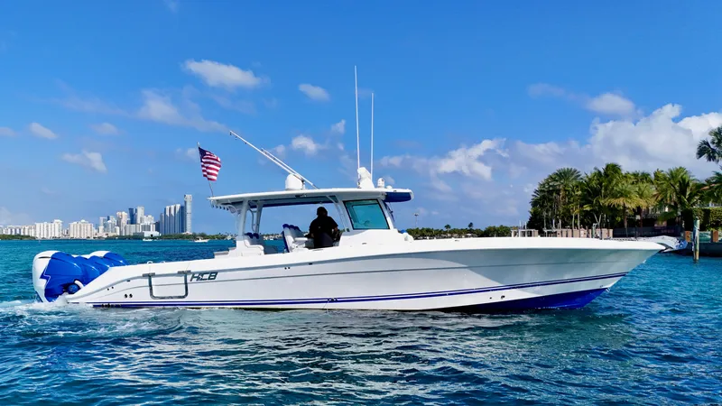 Slide: The Image of 2019 HCB 42 Siesta boat cruising on blue water with city skyline in background. - 30