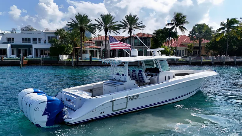 Slide: The Image of 2019 HCB 42 Siesta boat on water, American flag, luxury waterfront homes in background. - 32