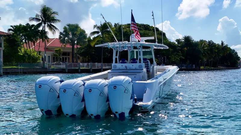 Slide: The Image of 2019 HCB 42 Siesta boat with four engines on a sunny day, near waterfront homes. - 43