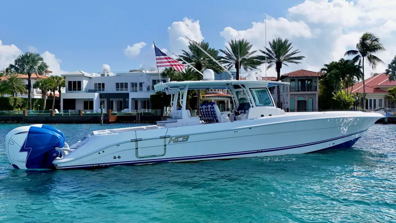 Slide: The Image of 2019 HCB 42 Siesta boat on turquoise water, with luxury homes and palm trees in the background. - 46