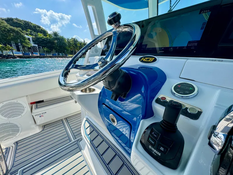 Slide: The Image of 2019 HCB 42 Siesta boat helm with steering wheel and control panel, near scenic waterfront. - 55