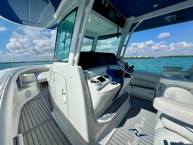 Slide: The Image of 2019 HCB 42 Siesta boat interior with helm, ocean view, and clear skies. - 56