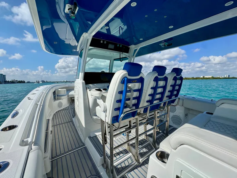 Slide: The Image of 2019 HCB 42 Siesta boat interior with blue seating, open water view. - 61