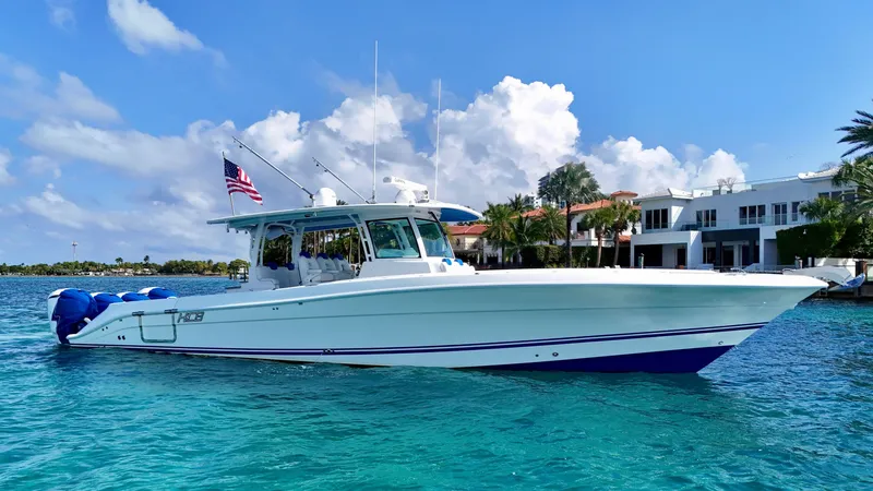 Slide: The Image of 2019 HCB 42 Siesta boat cruising on clear blue water near luxury waterfront homes. - 7