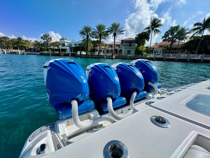 Slide: The Image of 2019 HCB 42 Siesta boat with four blue outboard engines on a sunny waterfront. - 76