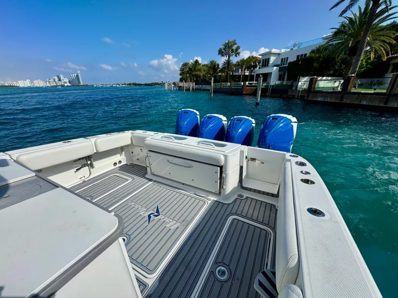 Slide: The Image of 2019 HCB 42 Siesta boat with four blue outboard engines, docked near luxury waterfront homes. - 79