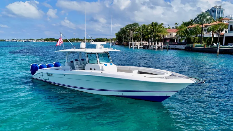 Slide: The Image of 2019 HCB 42 Siesta boat on clear blue water, near luxury waterfront homes. - 9