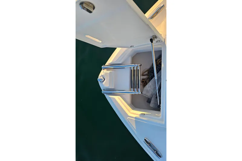 Slide: The Image of Open storage compartment on 2008 Regal 2700 ES Bowrider boat, featuring a folded ladder. - 11