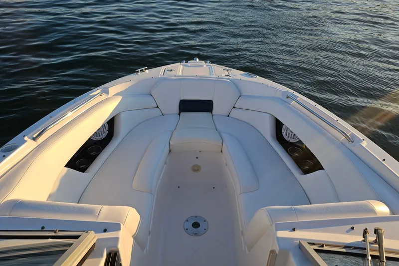 Slide: The Image of 2008 Regal 2700 ES Bowrider boat with white seating, on calm water. - 13