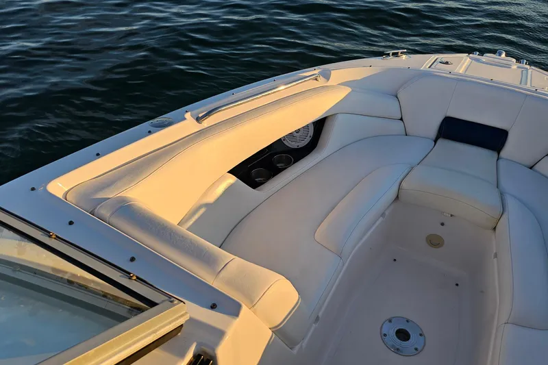 Slide: The Image of 2008 Regal 2700 ES Bowrider boat interior with white seating on water. - 14