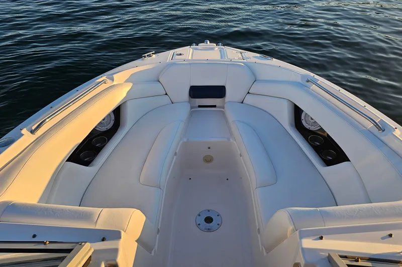 Slide: The Image of 2008 Regal 2700 ES Bowrider boat interior with white seating on calm water. - 19