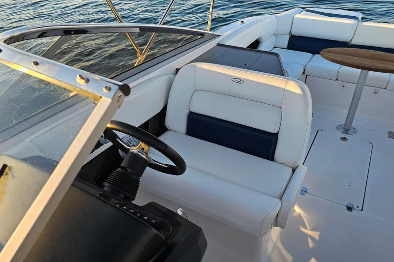 Slide: The Image of 2008 Regal 2700 ES Bowrider interior with steering wheel and seating, on calm water. - 20