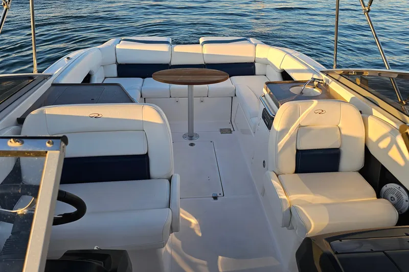 Slide: The Image of 2008 Regal 2700 ES Bowrider interior with white seating and wooden table on calm water. - 21