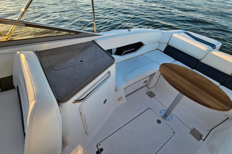 Slide: The Image of 2008 Regal 2700 ES Bowrider interior with seating and wooden table on water. - 25