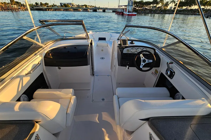 Slide: The Image of 2008 Regal 2700 ES Bowrider interior with steering wheel and seating, on calm water. - 26