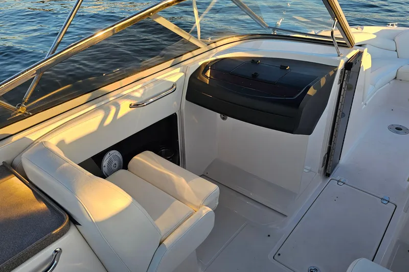 Slide: The Image of 2008 Regal 2700 ES Bowrider interior with seating and dashboard, on calm water. - 27