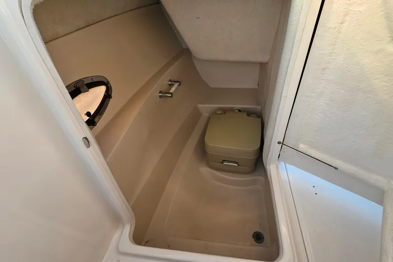 Slide: The Image of 2008 Regal 2700 ES Bowrider interior with portable toilet and porthole window. - 37