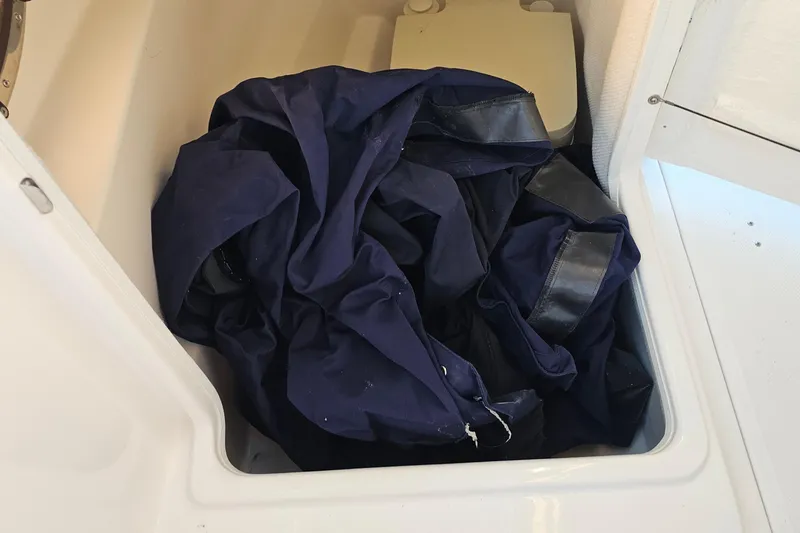 Slide: The Image of Storage compartment in a 2008 Regal 2700 ES Bowrider with a folded navy cover. - 38