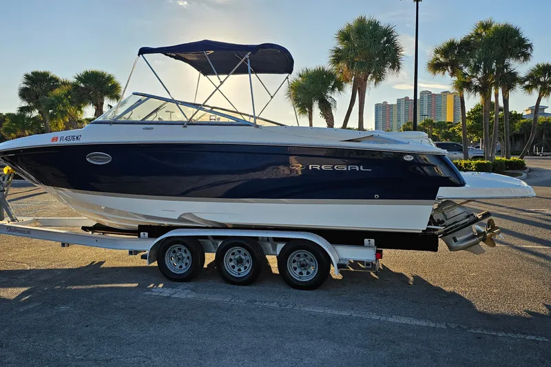 Slide: The Image of 2008 Regal 2700 ES Bowrider boat on trailer, parked with palm trees in the background. - 4
