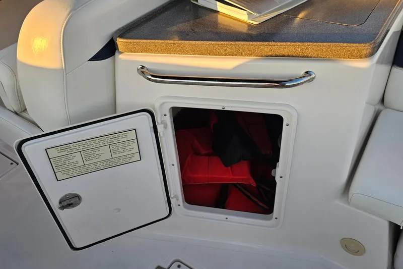 Slide: The Image of Open storage compartment on 2008 Regal 2700 ES Bowrider boat with life jackets inside. - 40