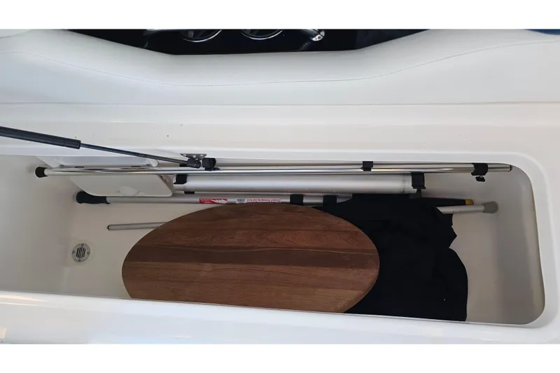 Slide: The Image of Storage compartment in 2008 Regal 2700 ES Bowrider with accessories and wooden panel. - 44