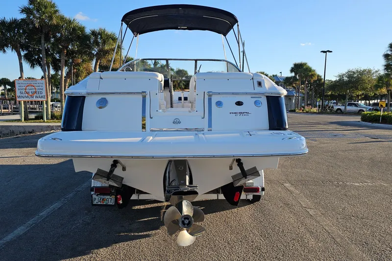 Slide: The Image of 2008 Regal 2700 ES Bowrider boat, rear view, parked with palm trees in background. - 5