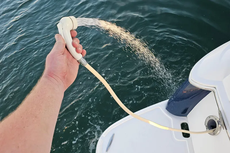Slide: The Image of Hand holding a shower hose on a 2008 Regal 2700 ES Bowrider boat. - 54