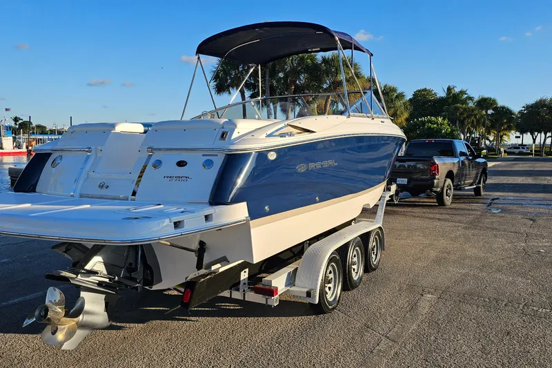 Slide: The Image of 2008 Regal 2700 ES Bowrider on trailer, parked near palm trees and a truck. - 6