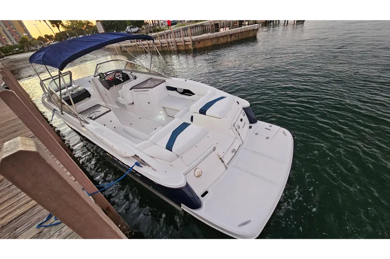 Slide: The Image of 2008 Regal 2700 ES Bowrider docked, featuring spacious seating and a blue canopy. - 62
