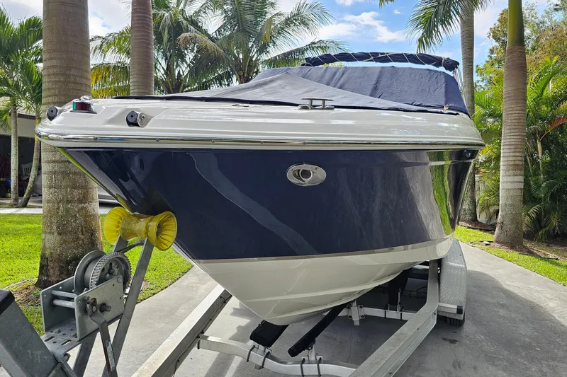 Slide: The Image of 2008 Regal 2700 ES Bowrider boat on trailer, surrounded by palm trees. - 76