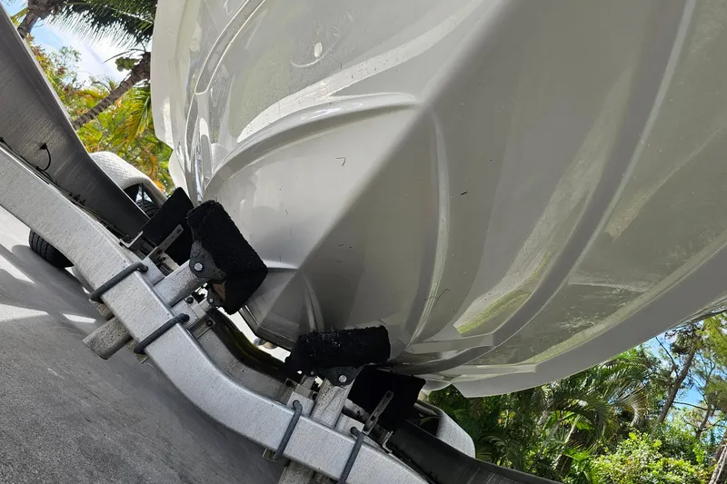 Slide: The Image of 2008 Regal 2700 ES Bowrider on trailer, underside view with lush greenery background. - 77