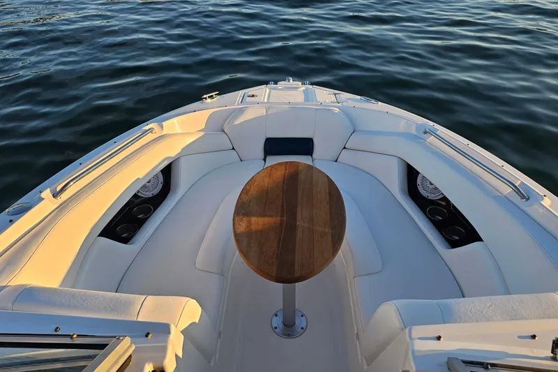 Slide: The Image of 2008 Regal 2700 ES Bowrider boat interior with seating and table on calm water. - 9