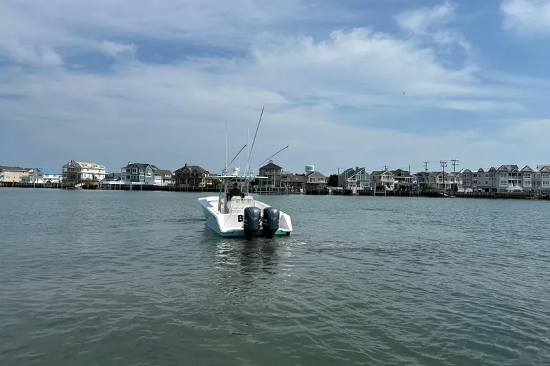 Slide: The Image of 2010 Jupiter 34 FS boat on calm water near coastal houses under a blue sky. - 11