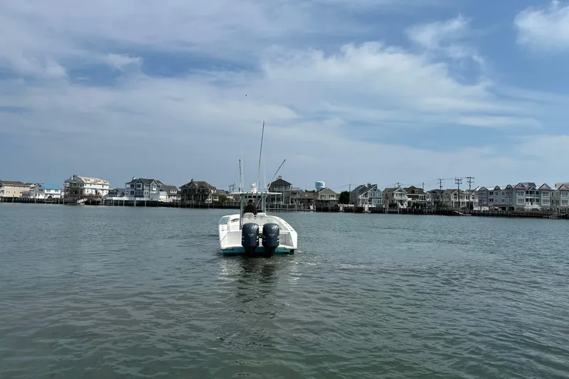 Slide: The Image of 2010 Jupiter 34 FS boat cruising near coastal homes under a blue sky. - 14