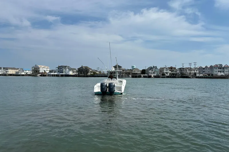 Slide: The Image of 2010 Jupiter 34 FS boat on calm water with coastal houses in the background. - 15