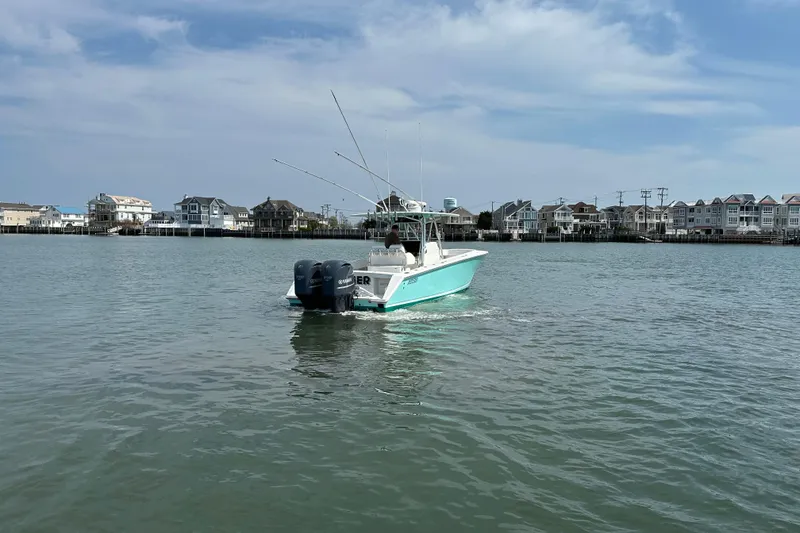 Slide: The Image of 2010 Jupiter 34 FS boat cruising near coastal homes under a clear sky. - 18