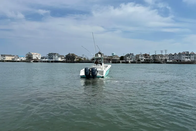 Slide: The Image of 2010 Jupiter 34 FS boat cruising near coastal homes under a partly cloudy sky. - 19