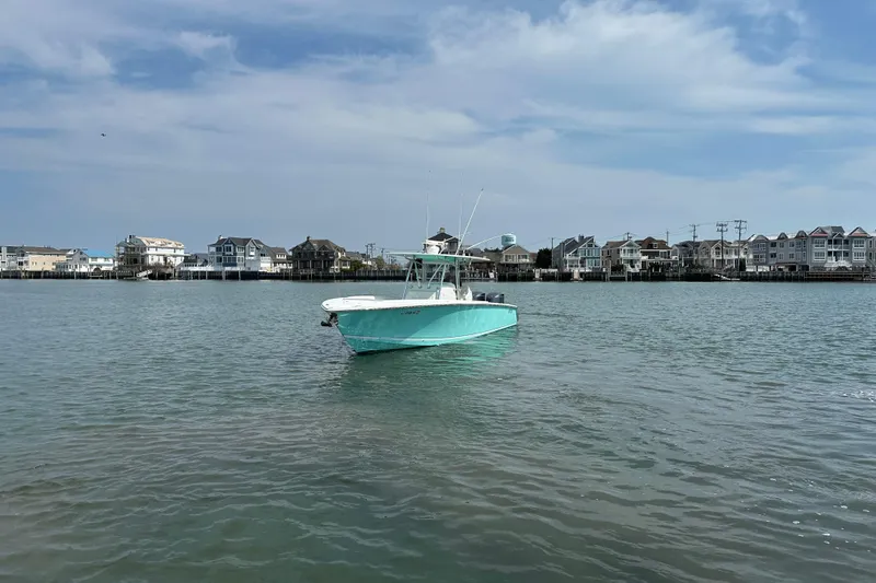 Slide: The Image of 2010 Jupiter 34 FS boat on calm water with coastal houses in the background. - 2