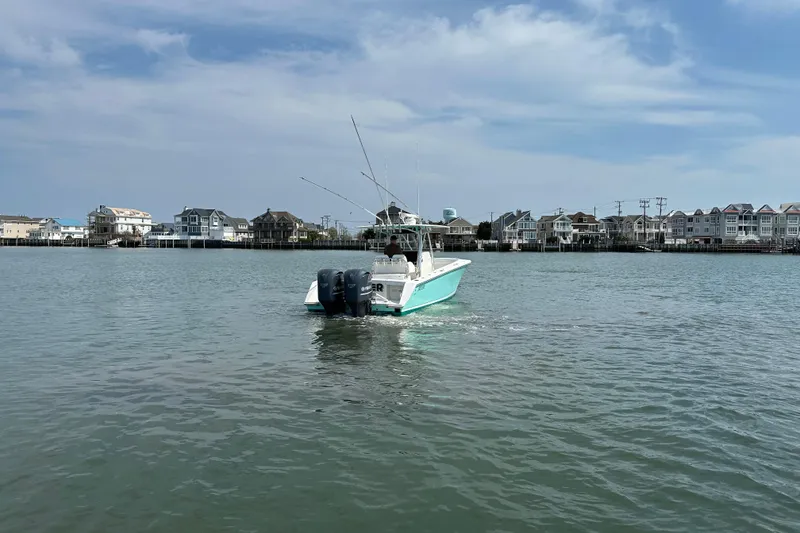 Slide: The Image of 2010 Jupiter 34 FS boat cruising near coastal homes under a clear sky. - 20