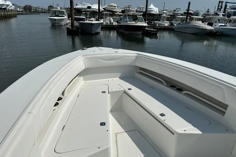 Slide: The Image of 2010 Jupiter 34 FS boat docked in a marina, showcasing spacious seating area. - 24