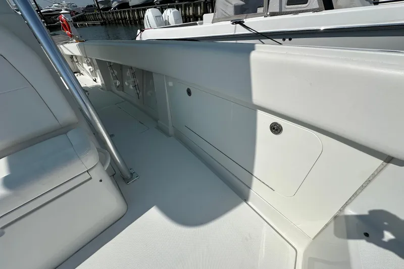Slide: The Image of 2010 Jupiter 34 FS boat interior with white seating and storage compartments. - 32