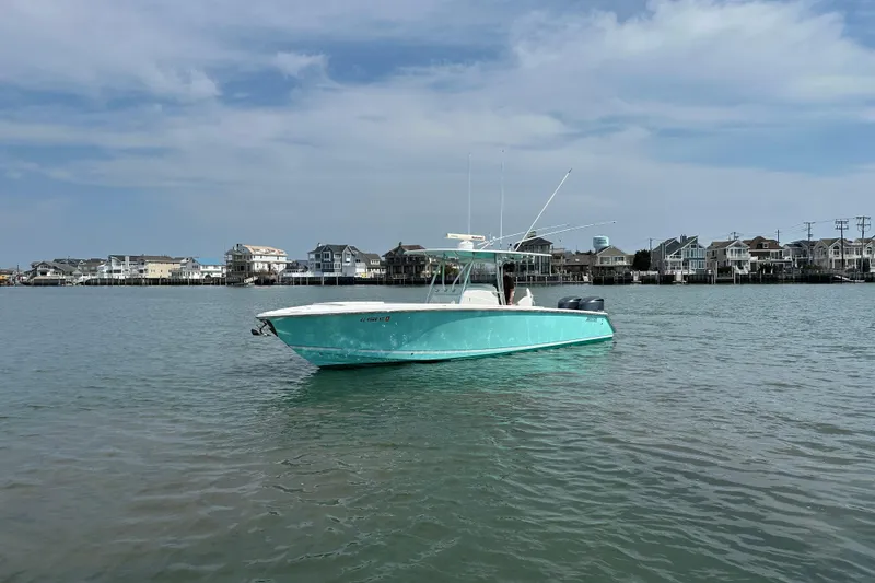 Slide: The Image of 2010 Jupiter 34 FS boat on calm water with coastal houses in the background. - 5